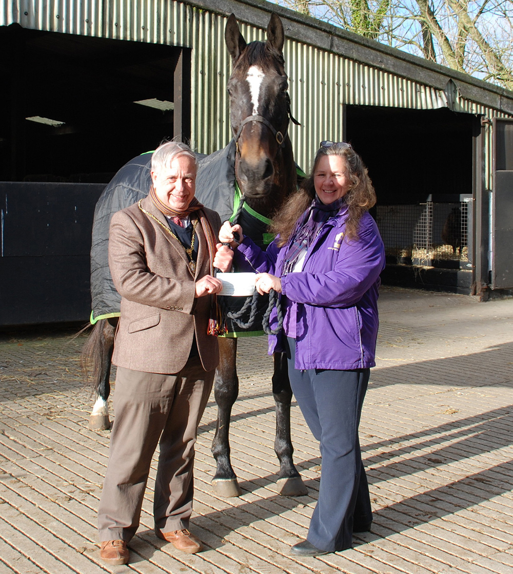 Marlborough Town Mayor Cllr Mervyn Hall handing over a cheque for &pound;427 to Jane Muir-Brooks of Greatwood, with supervision from Louis
